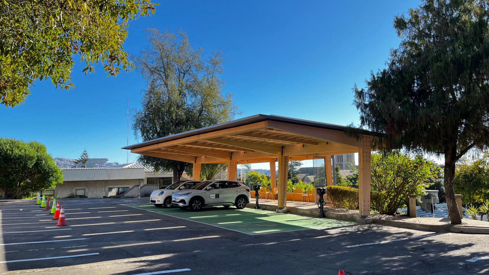 Estación solar de carga Punto EV en el campus de la USM: cubierta de madera laminada con autos eléctricos cargando en bahías verdes